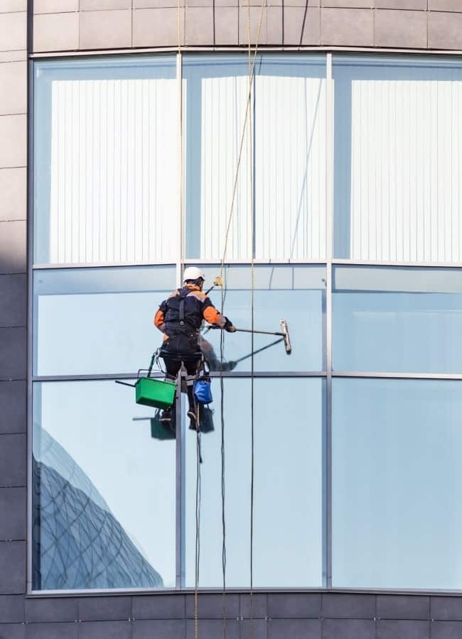 Professional window washer cleaning exterior building glass